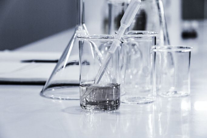 Laborgefäße mit Flüssigkeit, darunter ein Becherglas mit Pipette